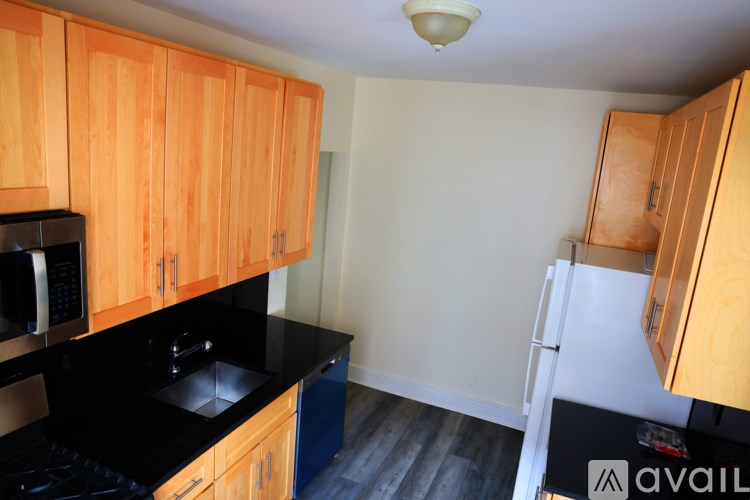 A kitchen with wooden cabinets and black countertops.