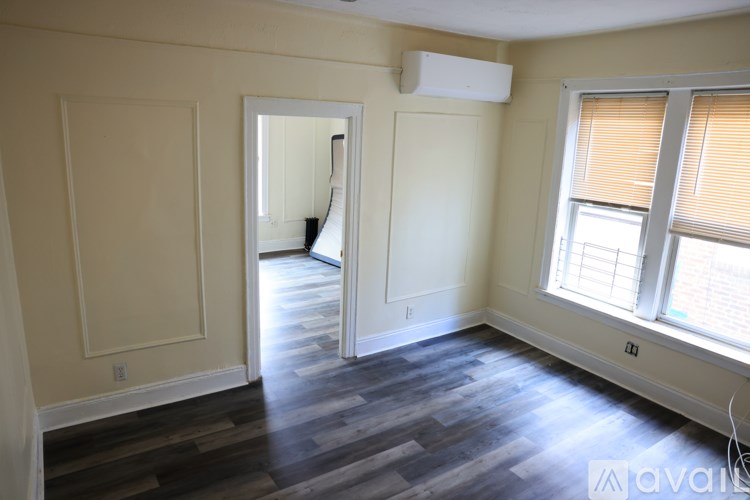 A room with a window and a door leading to another room.