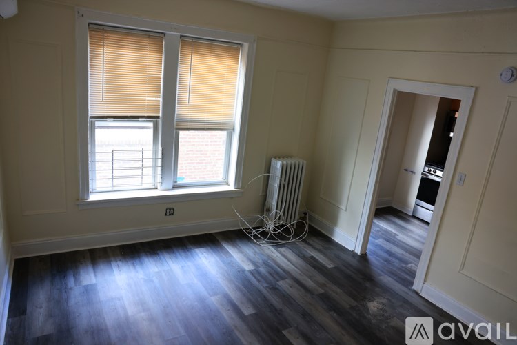 A room with a window and a radiator on the floor.
