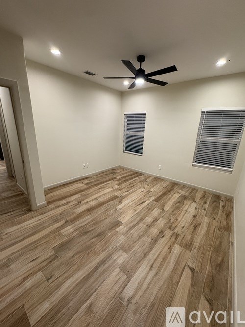 A room with wooden flooring and a ceiling fan.