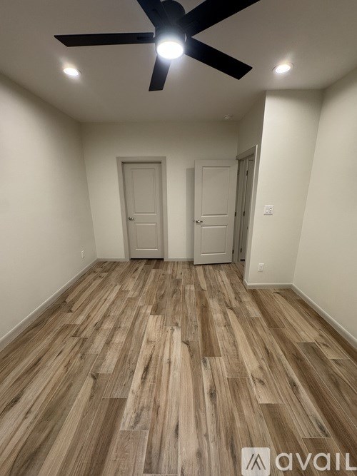 A room with wooden flooring and a ceiling fan.