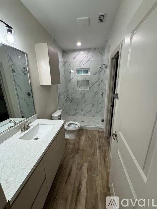 A bathroom with a marble shower and toilet.