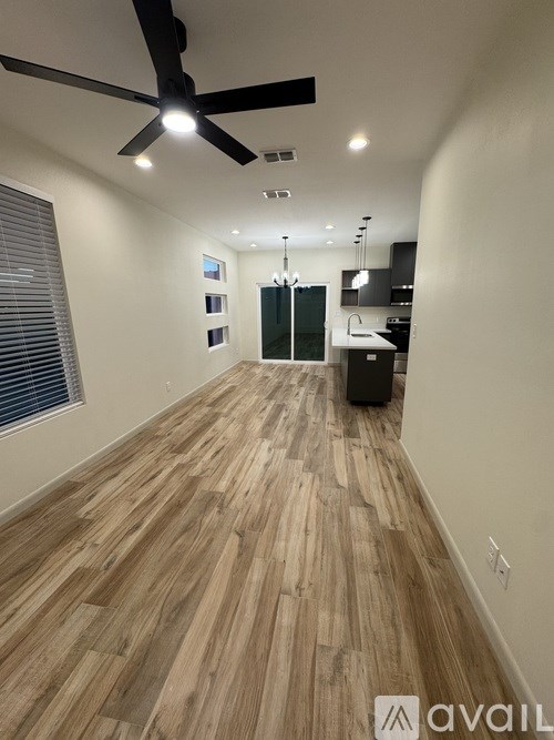 A long hallway with wooden floors and a ceiling fan.