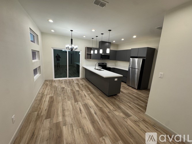A modern kitchen with wooden flooring and a central island.