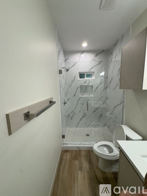 A bathroom with a marble wall and a toilet.