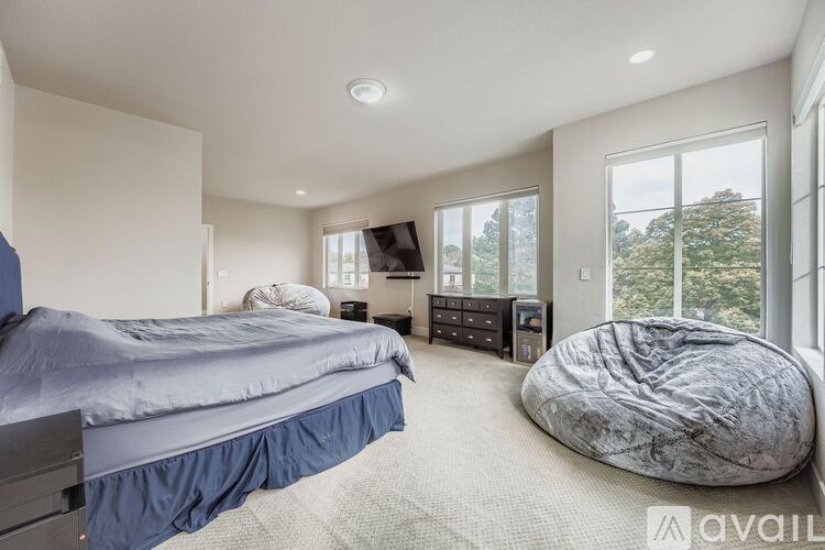 A bedroom with a large bed and a bean bag chair.