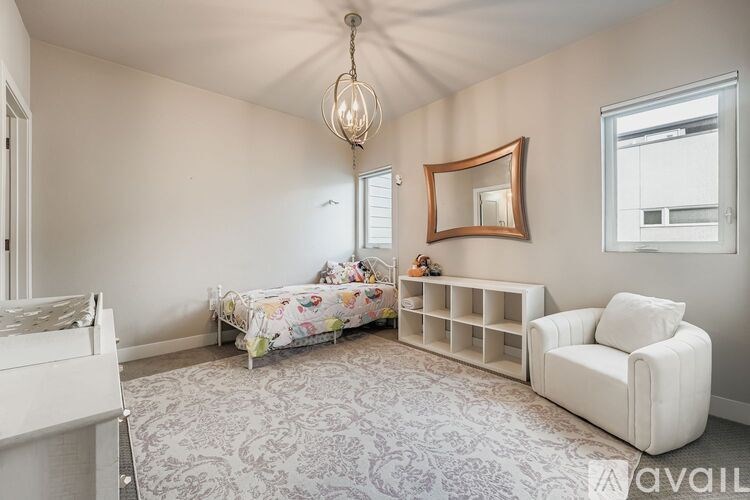 A bedroom with a floral bedspread and a white couch.