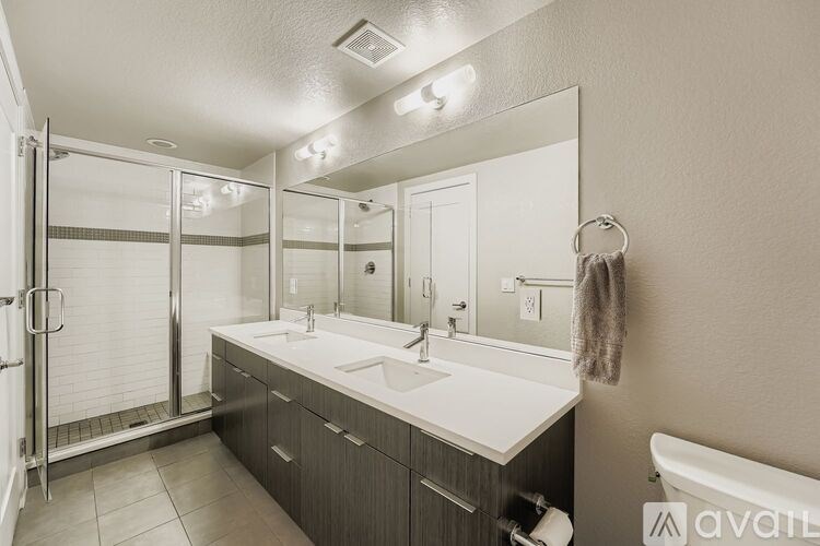 A bathroom with a white sink and a glass shower stall.