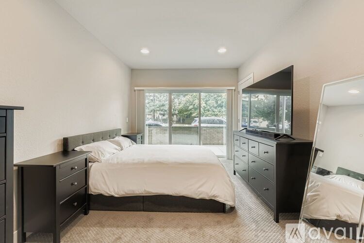 A bedroom with a large bed and a dresser with a mirror.