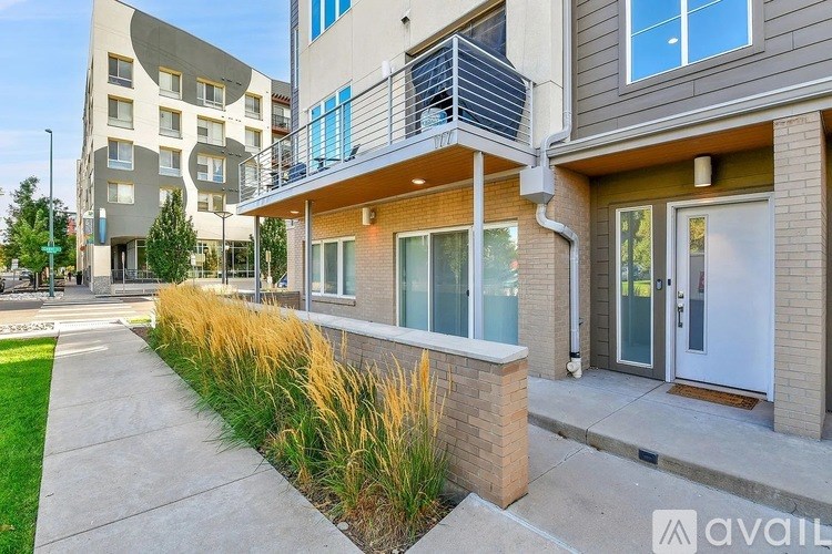 A modern two-story building with a balcony and glass doors.