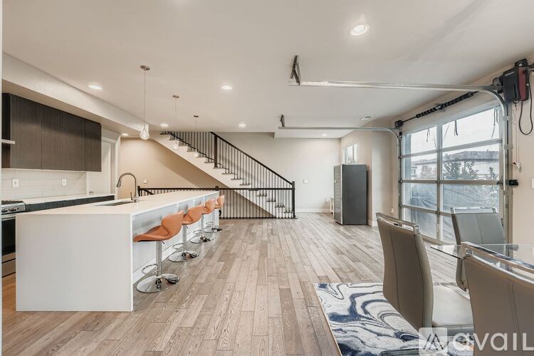 A modern kitchen with a bar area and a staircase.