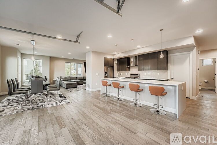A modern open plan living and kitchen area with a bar stool.