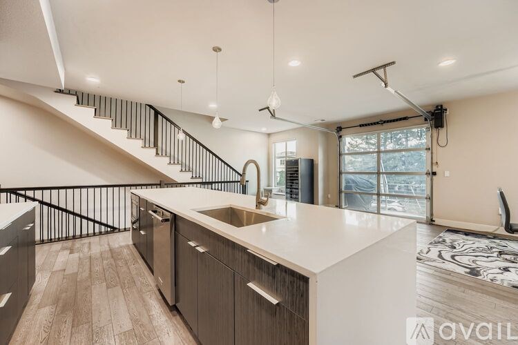 A modern kitchen with a staircase leading to the upper floor.