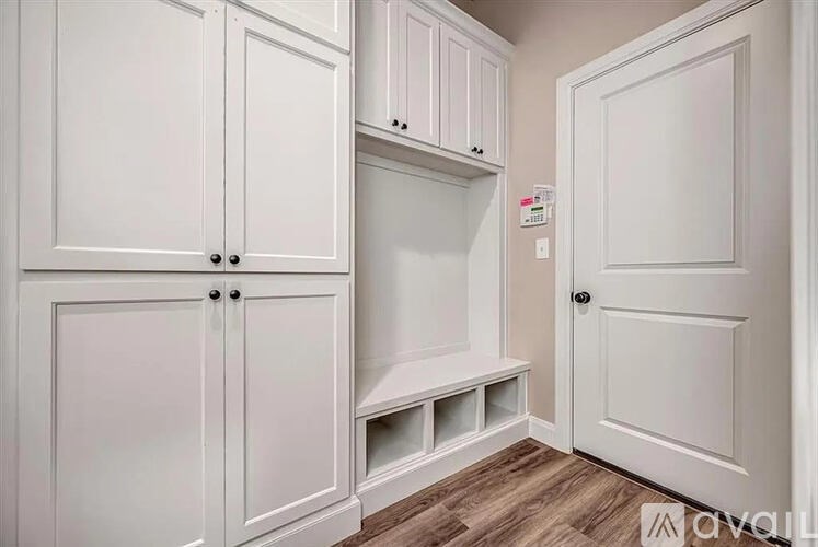 A kitchen with white cabinets and a wooden floor.