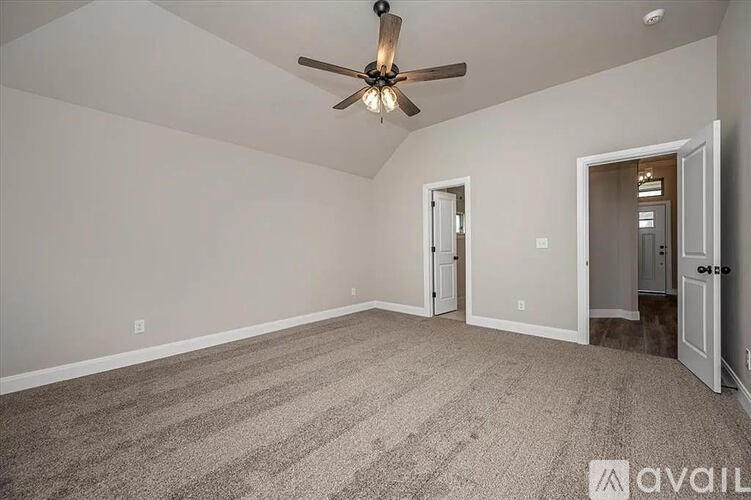 A room with a ceiling fan and carpeted floor.