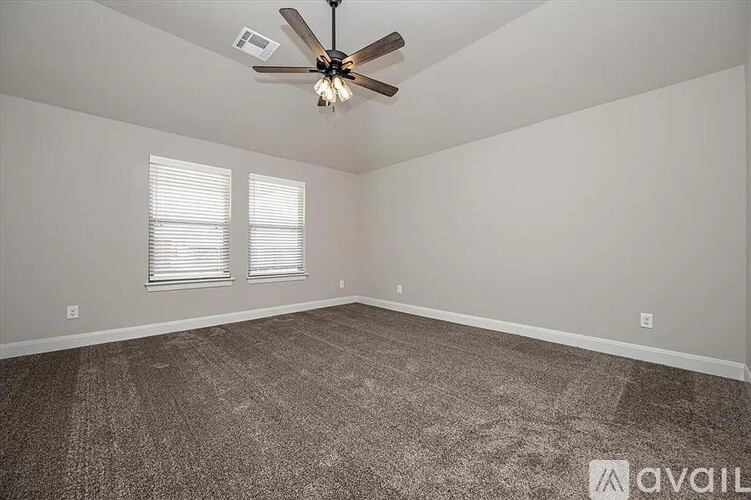 A room with a ceiling fan and carpeted floor.