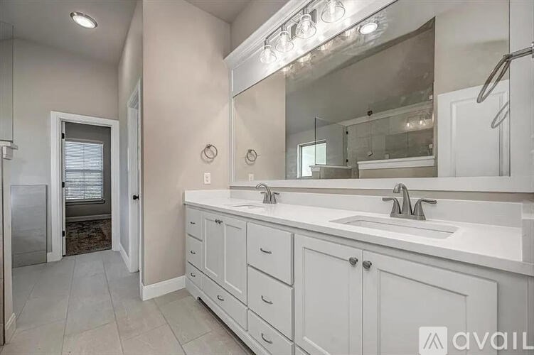 A bathroom with a sink, mirror, and cabinets.