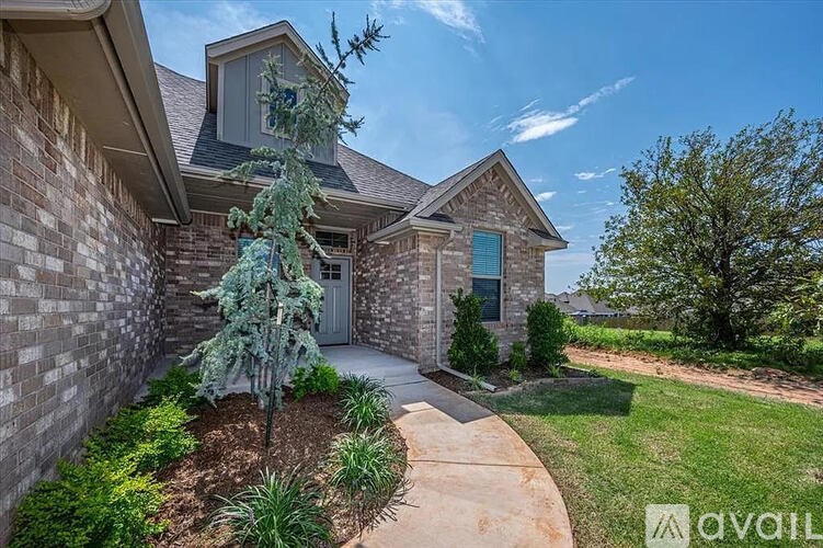 A house with a grey door and a small tree in front of it.