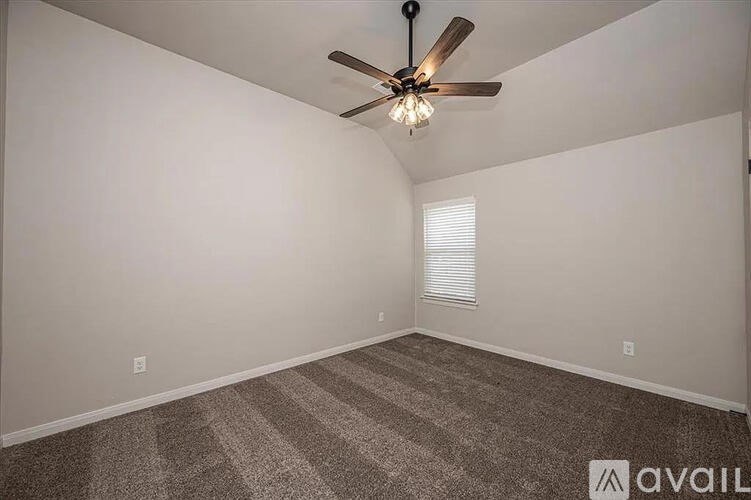 A room with a ceiling fan and carpeted floor.