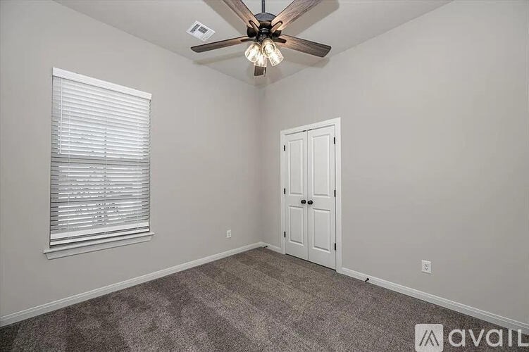A room with a ceiling fan and a door.