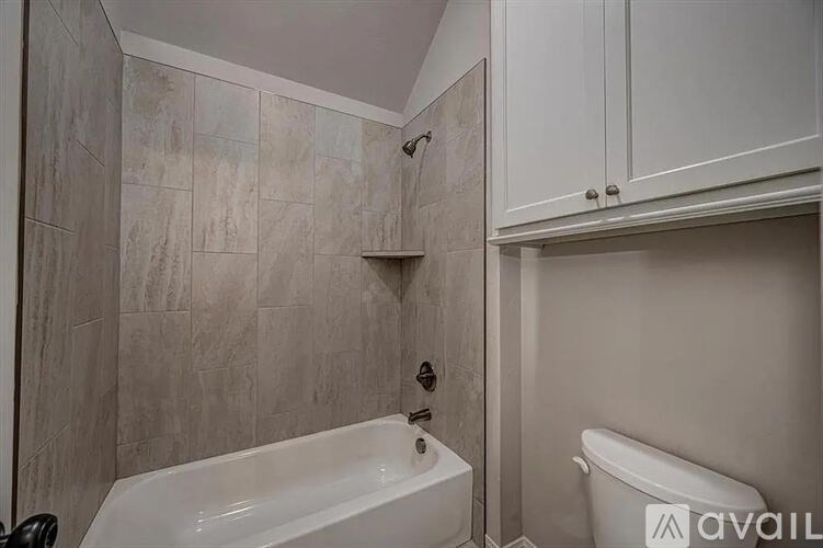 A bathroom with a tub and a toilet.