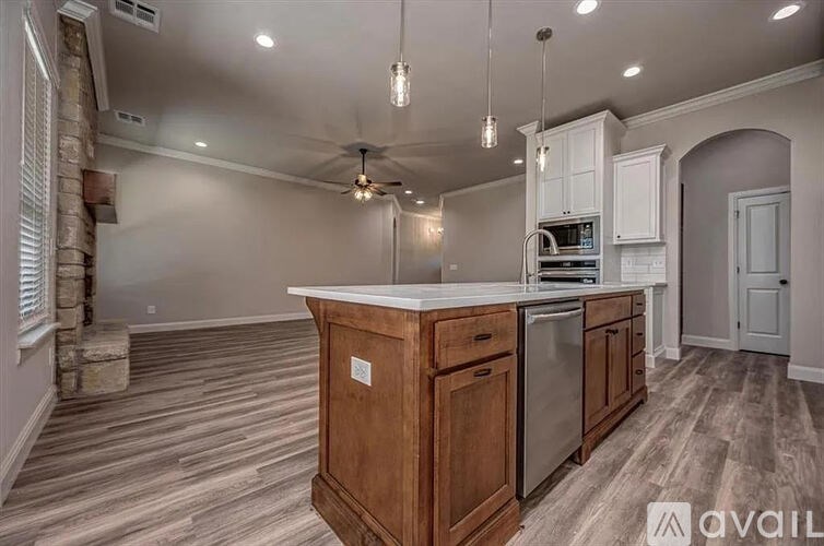 A kitchen with a wooden island and stainless steel appliances.
