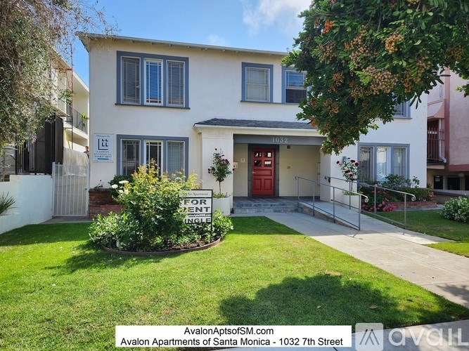 A white two-story house with a red door and a sign that says "For Rent".