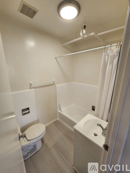 A white bathroom with a toilet, sink, and bathtub.