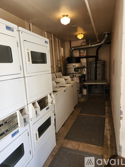 A row of white ovens are lined up in a narrow room.