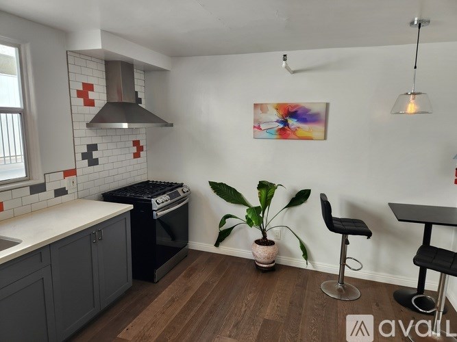 A kitchen with a black dishwasher and a plant in a white pot.