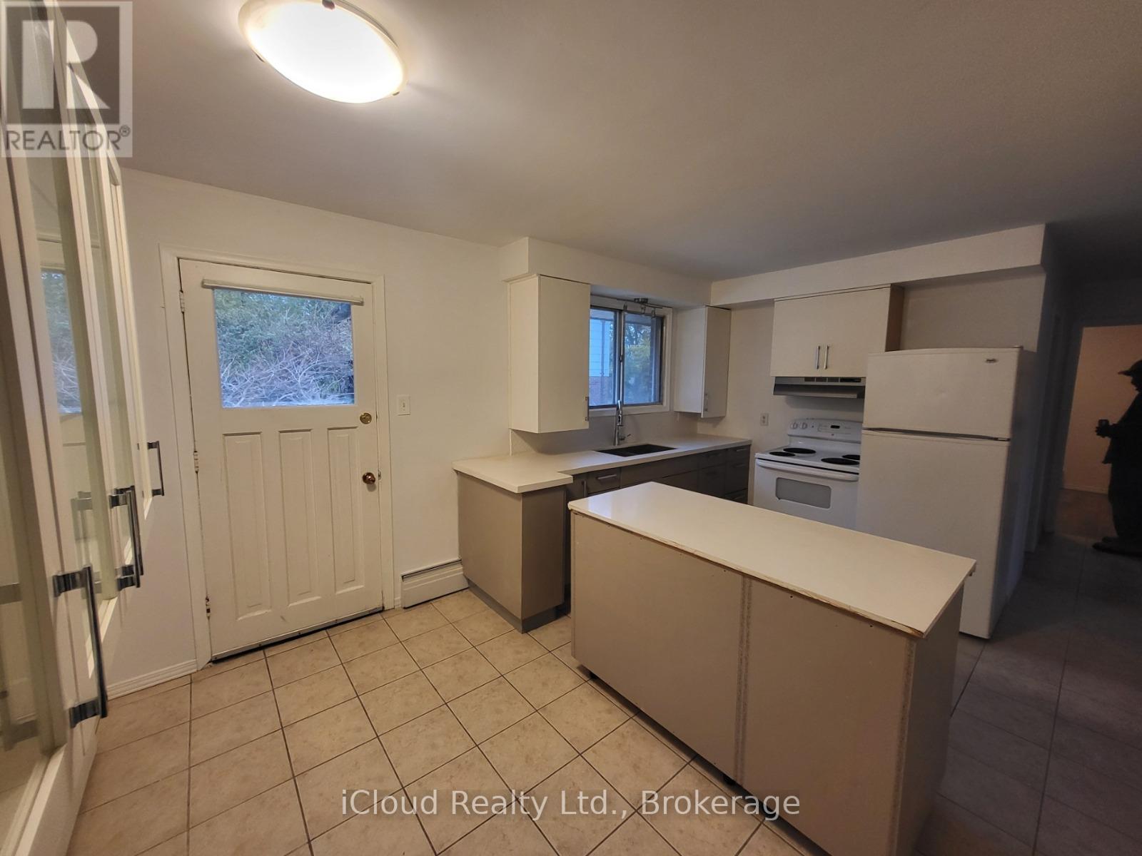 A kitchen with a white door and a window.