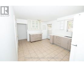 A kitchen with a white door and a window.