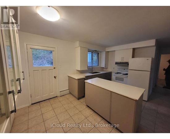 A kitchen with a white door and a window.