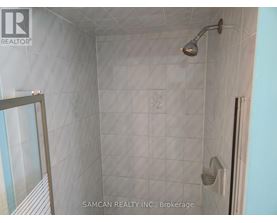 A shower area with a glass door and a shower head.