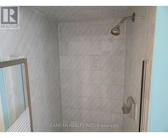 A shower area with a glass door and a shower head.