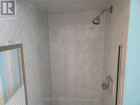 A shower area with a glass door and a shower head.