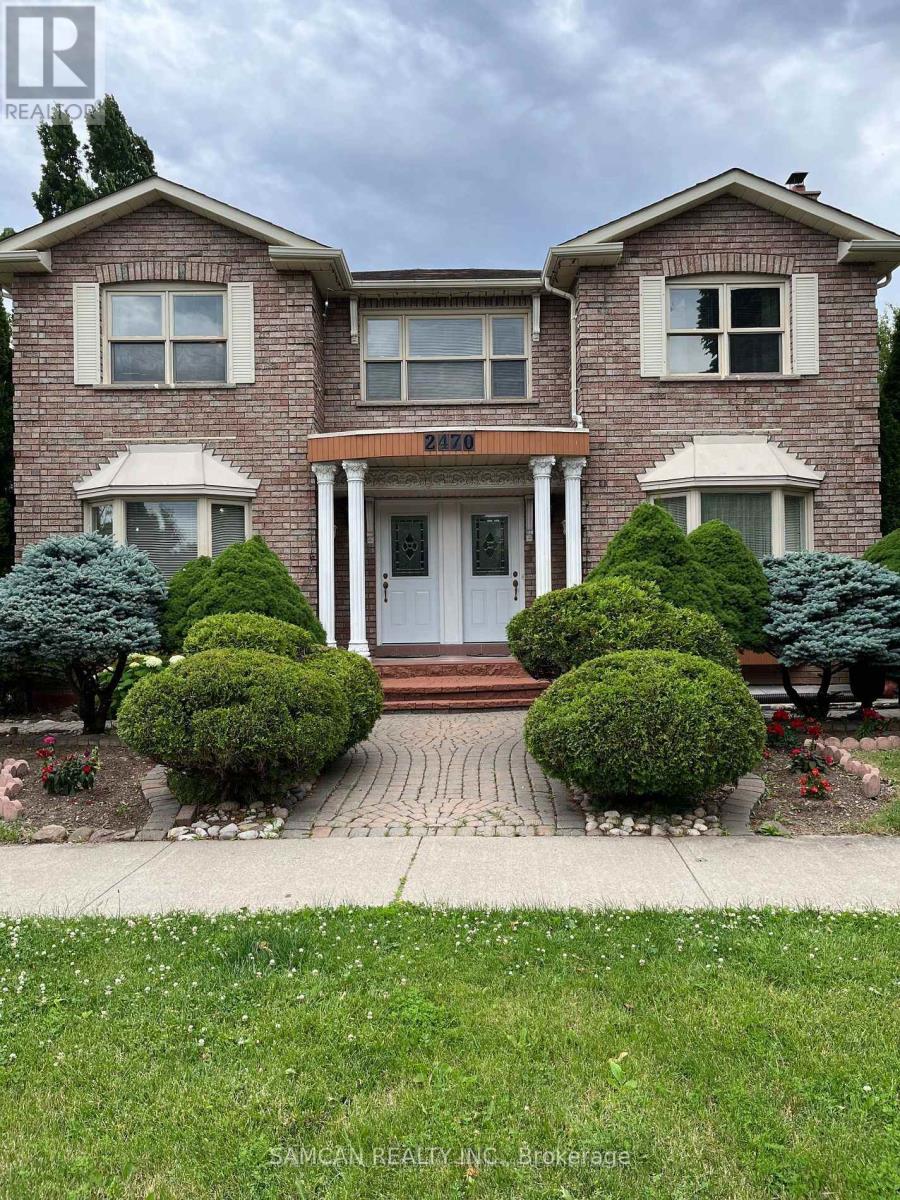 A house with a front yard and bushes.