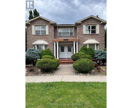 A house with a front yard and bushes.
