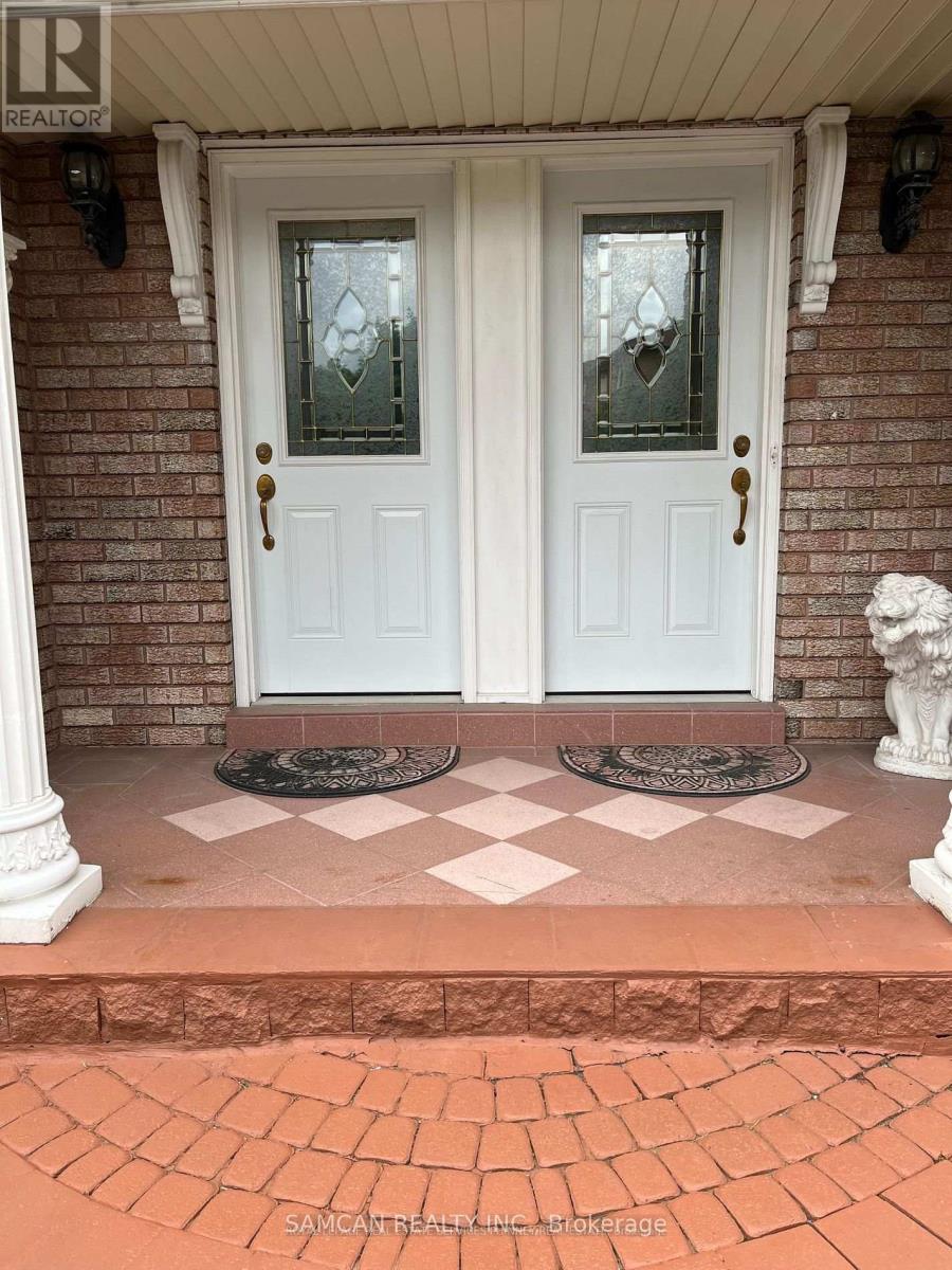 A white double door with glass panels and sidelights is set in a brick wall.