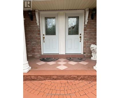 A white double door with glass panels and sidelights is set in a brick wall.