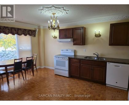 A kitchen with a table and chairs in front of a window.
