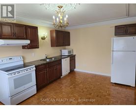 A kitchen with a white stove and brown cabinets.
