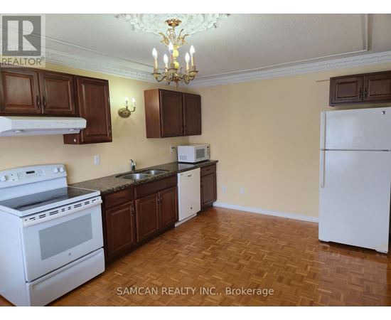 A kitchen with a white stove and brown cabinets.