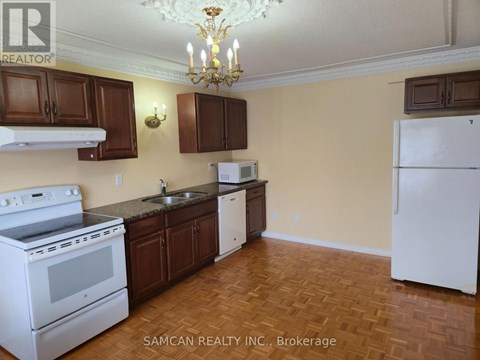 A kitchen with a white stove and brown cabinets.