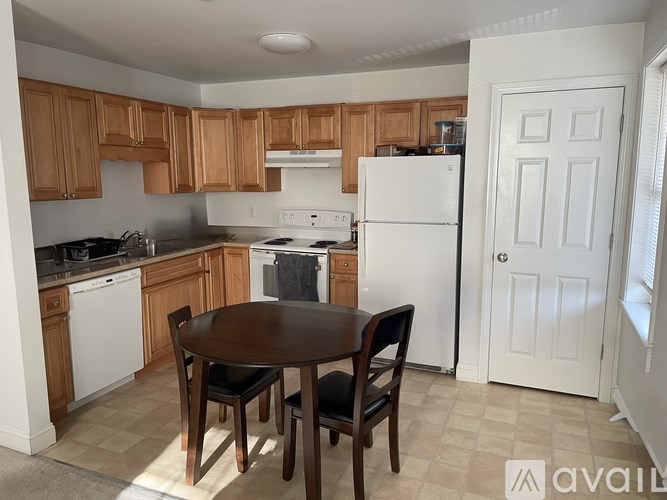 A kitchen with wooden cabinets and a white refrigerator.