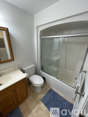 A bathroom with a toilet, sink, and shower.