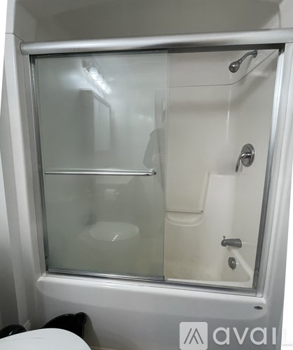 A white bathroom with a glass shower door.