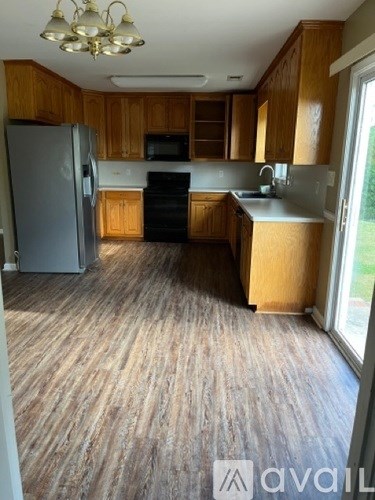 A kitchen with wooden cabinets and a grey refrigerator.