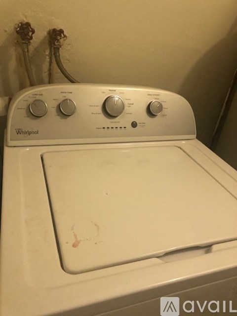 A Whirlpool washing machine with a white top and a white door.