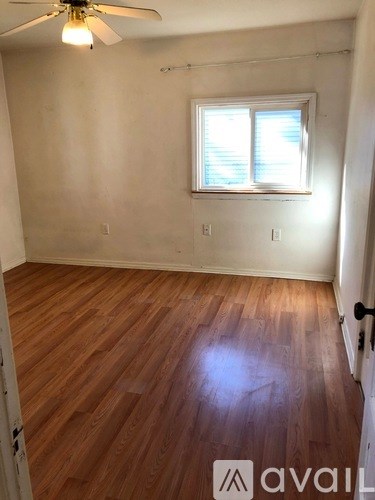 A room with wooden flooring and a ceiling fan.